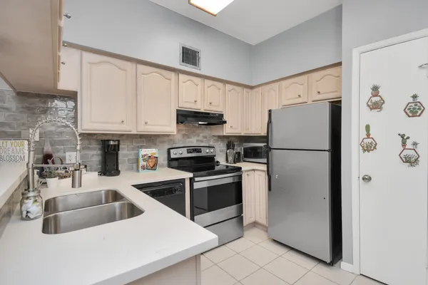 a kitchen with stainless steel appliances granite countertop a refrigerator a sink a stove a microwave and cabinets