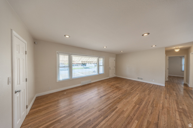 193 Locust Street Clearfield, UT 84015 - Photo 6 of 29 Spacious living area featuring wood-finish flooring, recessed lighting, and a large multi-pane window with blinds