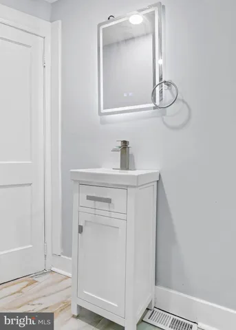 a bathroom with a sink a mirror and vanity