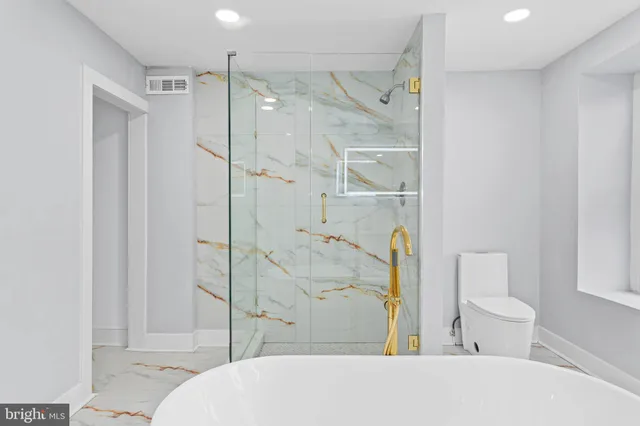 a bathroom with a toilet and a shower