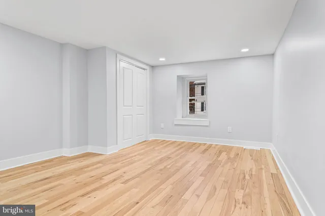 a view of empty room with wooden floor