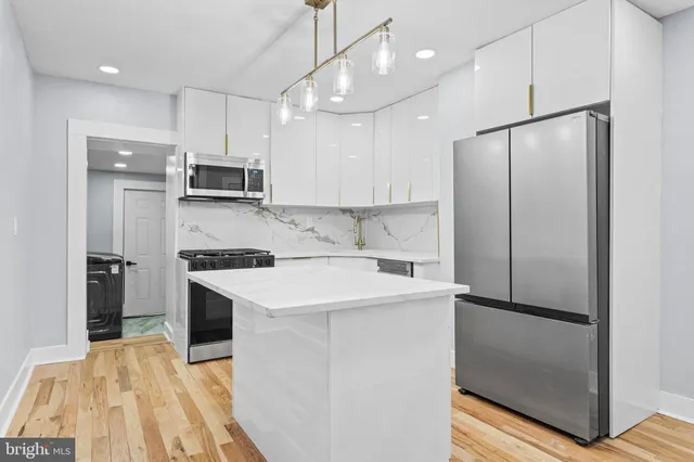 a kitchen with kitchen island a sink stainless steel appliances and refrigerator