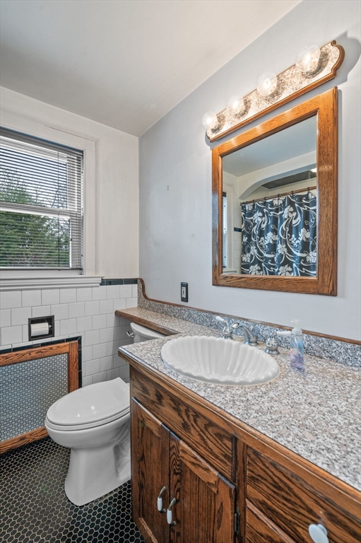 5 Prospect Street Danvers, MA 01923 - Photo 16 of 42 a bathroom with a granite countertop toilet a sink and a bathtub