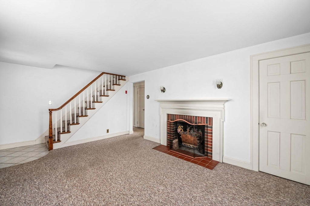 5 Prospect Street Danvers, MA 01923 - Photo 5 of 42 a view of an empty room with fireplace stairs and a window