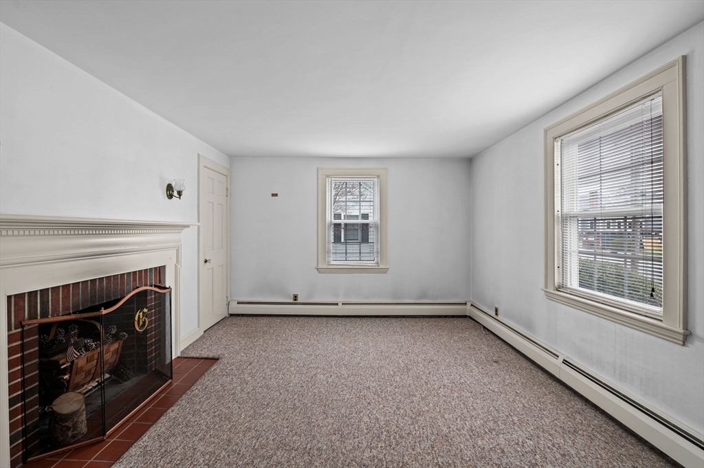 5 Prospect Street Danvers, MA 01923 - Photo 8 of 42 a view of an empty room with a fireplace and a window