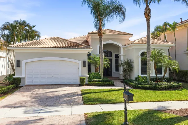 a front view of a house with a garden and plants