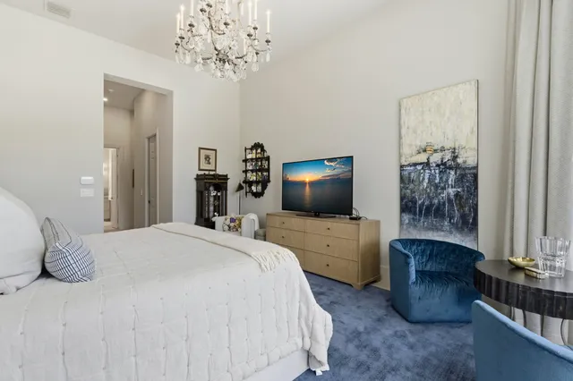 a bedroom with a large bed and a flat tv screen on dresser