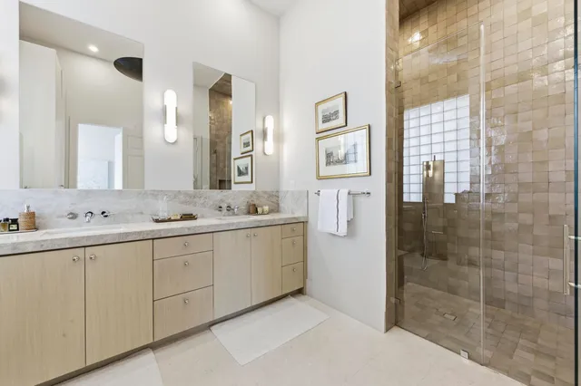 a bathroom with a double vanity sink mirror and shower