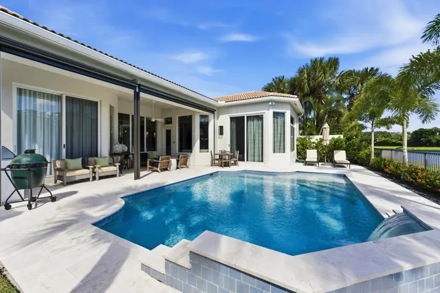a view of a house with swimming pool and sitting area