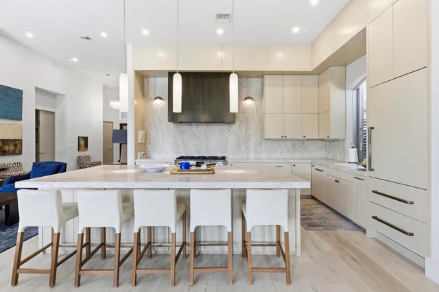 a kitchen with cabinets and chairs