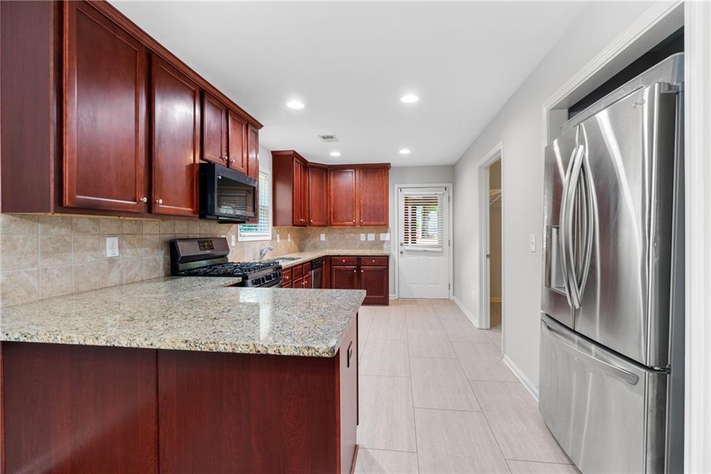 3159 Robinson Avenue Scottdale, GA 30079 - Photo 13 of 45 a kitchen with stainless steel appliances granite countertop a refrigerator a stove a sink dishwasher and wooden cabinets with a granite countertops