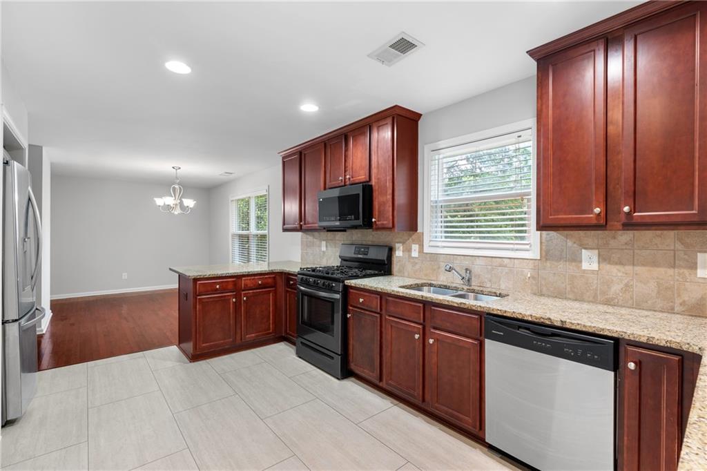 3159 Robinson Avenue Scottdale, GA 30079 - Photo 15 of 45 a kitchen with stainless steel appliances granite countertop wooden cabinets a sink and a stove