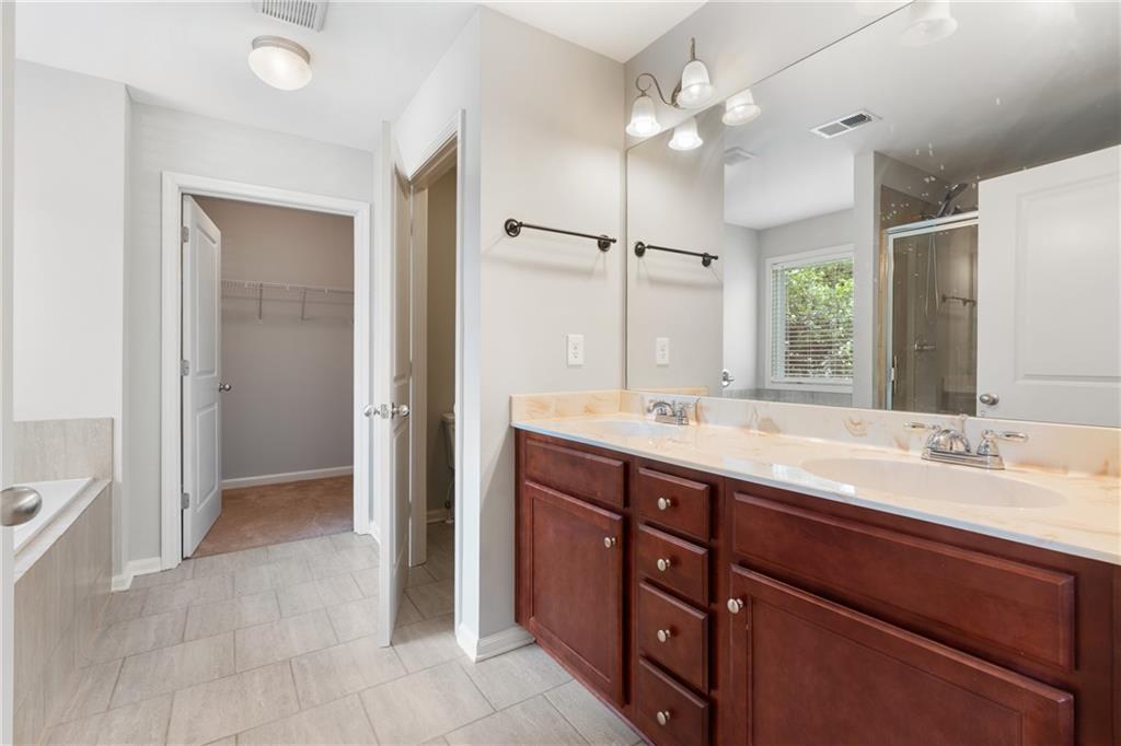3159 Robinson Avenue Scottdale, GA 30079 - Photo 21 of 45 a bathroom with a granite countertop sink a large mirror and a shower