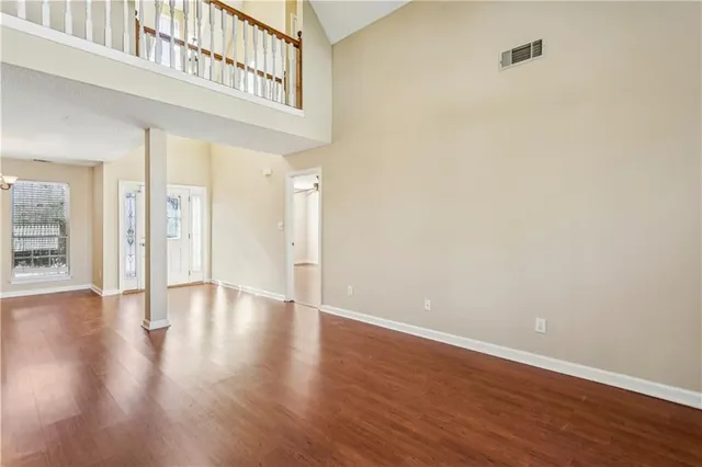 a view of an empty room with wooden floor