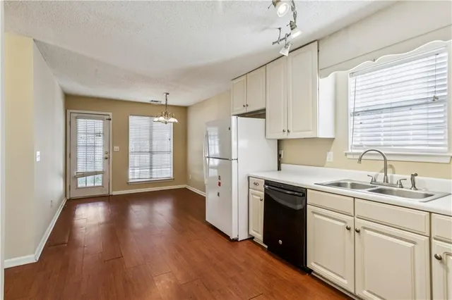 a kitchen with a sink a window a refrigerator and cabinets