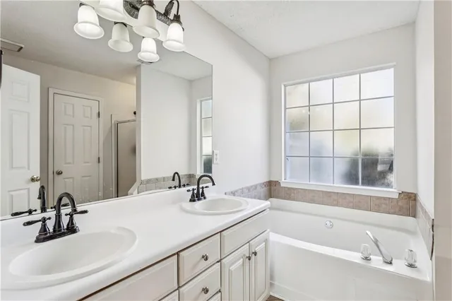 a bathroom with a sink a large mirror and a bathtub