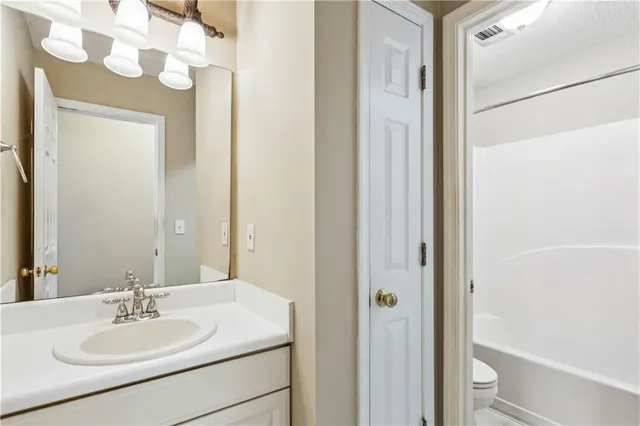 a bathroom with a sink vanity mirror and a toilet