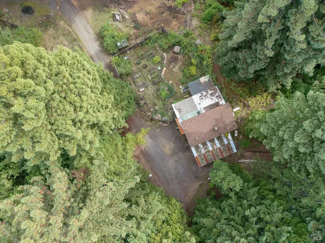 a view of house with car parked beside of a road