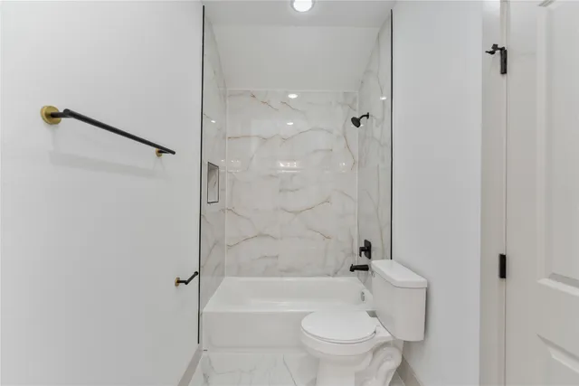 a bathroom with a shower a bathtub and toilet