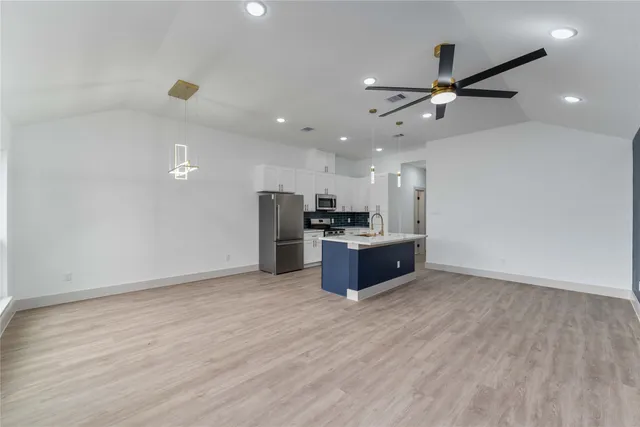 a kitchen with stainless steel appliances kitchen island a sink and a refrigerator