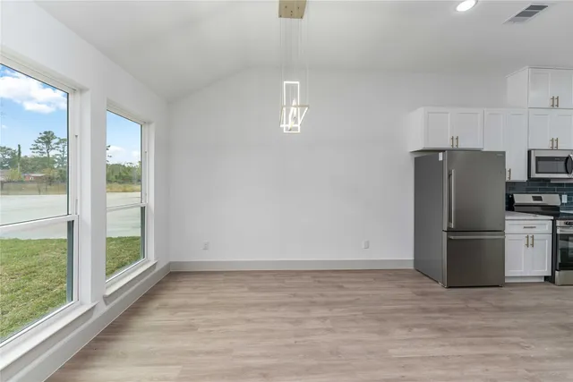 a view of a kitchen with a sink refrigerator and wooden floor