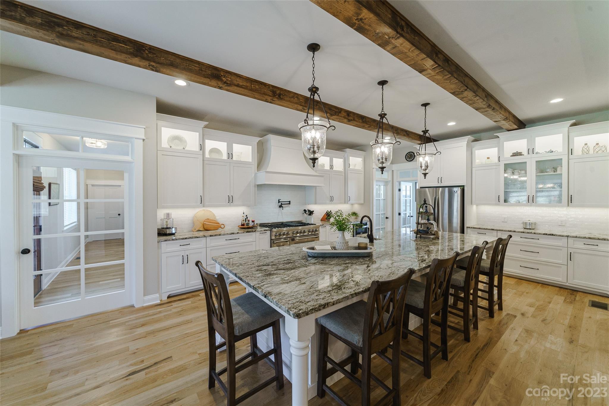 16063 McLester Road Oakboro, NC 28129 - Photo 13 of 48 a dining room with stainless steel appliances kitchen island granite countertop a table chairs and a wooden floor