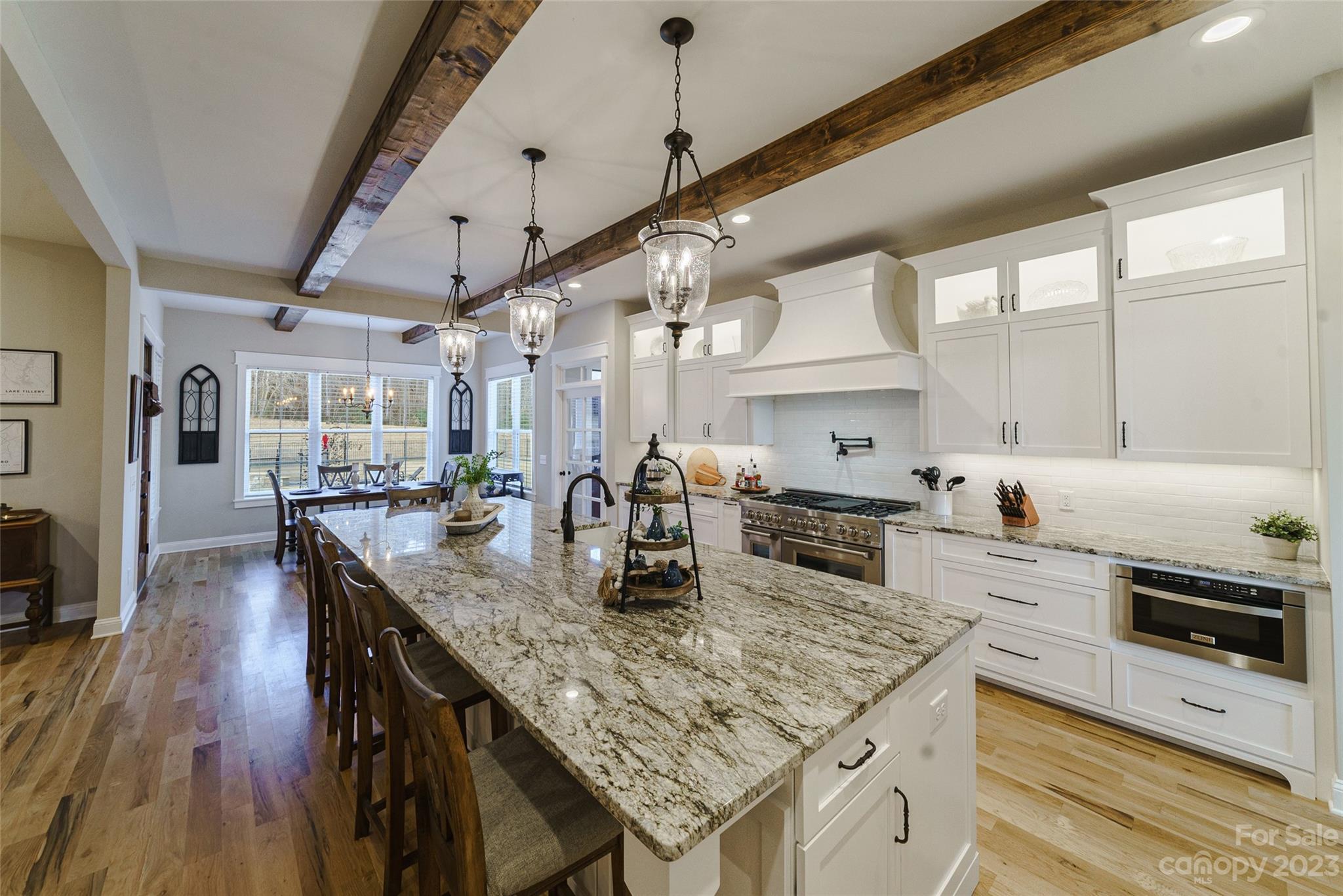 16063 McLester Road Oakboro, NC 28129 - Photo 14 of 48 a kitchen with stainless steel appliances granite countertop a kitchen island a stove a sink dishwasher and white cabinets with wooden floor
