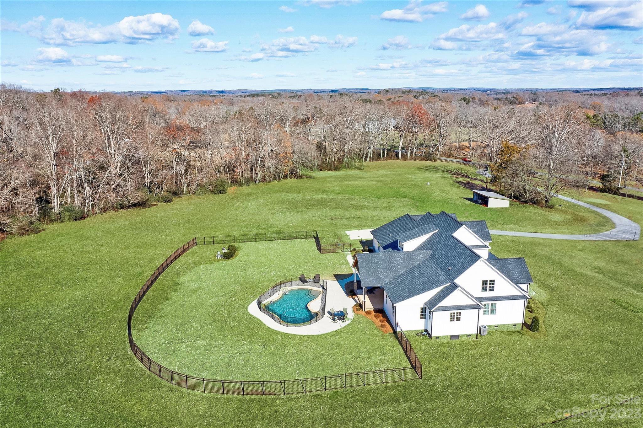 16063 McLester Road Oakboro, NC 28129 - Photo 3 of 48 a view of a swimming pool with an outdoor space and seating area