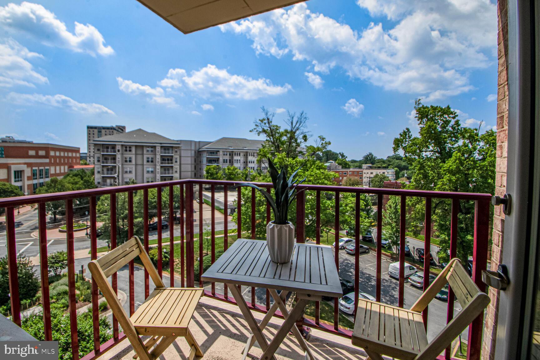1220 Blair Mill Road, Unit 605 Silver Spring, MD 20910 - Photo 31 of 46 a view of a balcony with wooden chairs and floor to ceiling window
