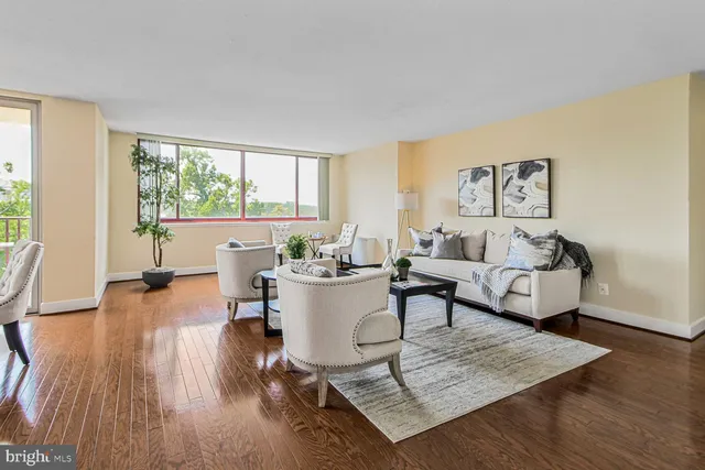 a living room with fireplace furniture and a large window