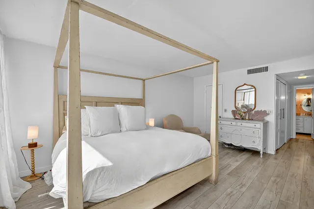 a bedroom with a bed and wooden floor