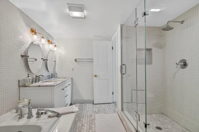a bathroom with a sink a mirror and shower