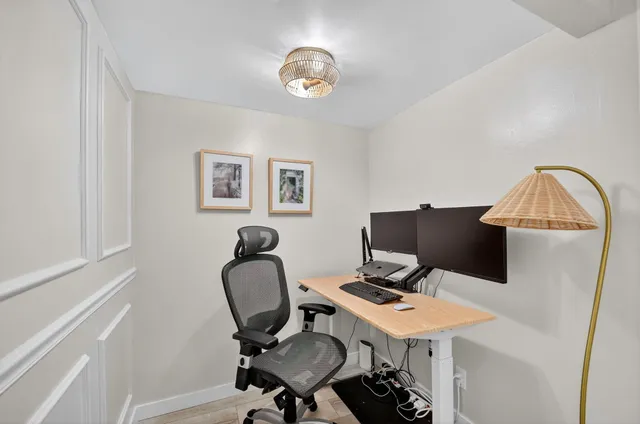 a view of a workspace with furniture and a window