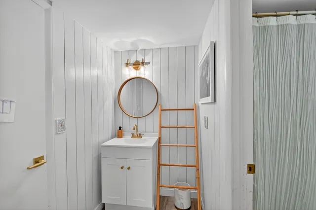 a bathroom with a sink vanity mirror and toilet