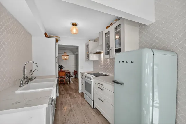 a kitchen with stainless steel appliances a stove a sink and a refrigerator