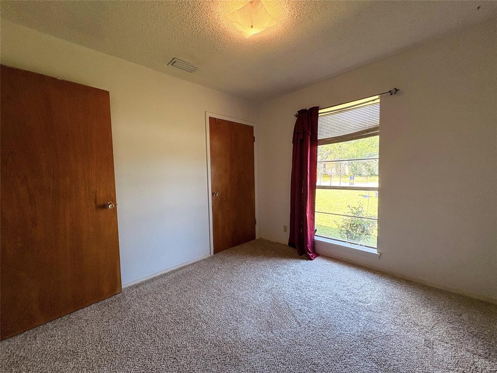 1829 South Center Street Denison, TX 75021 - Photo 19 of 29 an empty room with a window and a fireplace