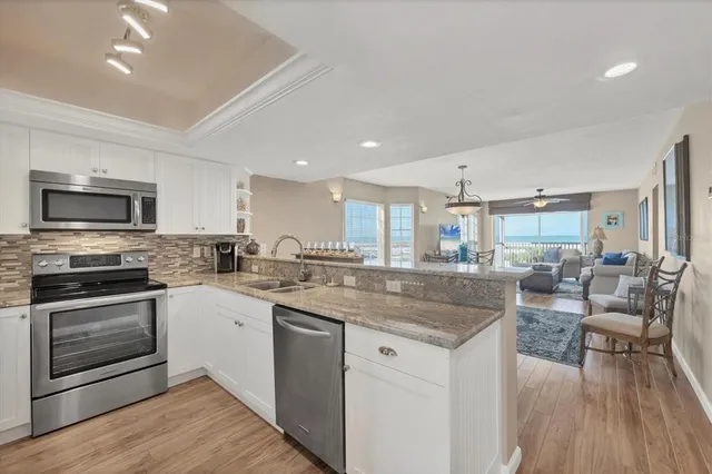 a kitchen with granite countertop a refrigerator stove and sink