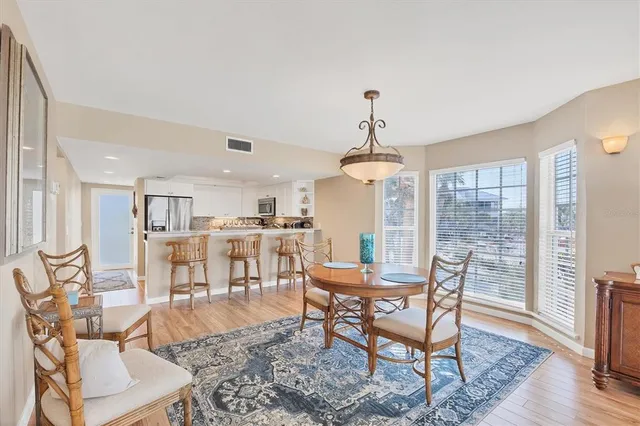 a living room with furniture kitchen view and a chandelier