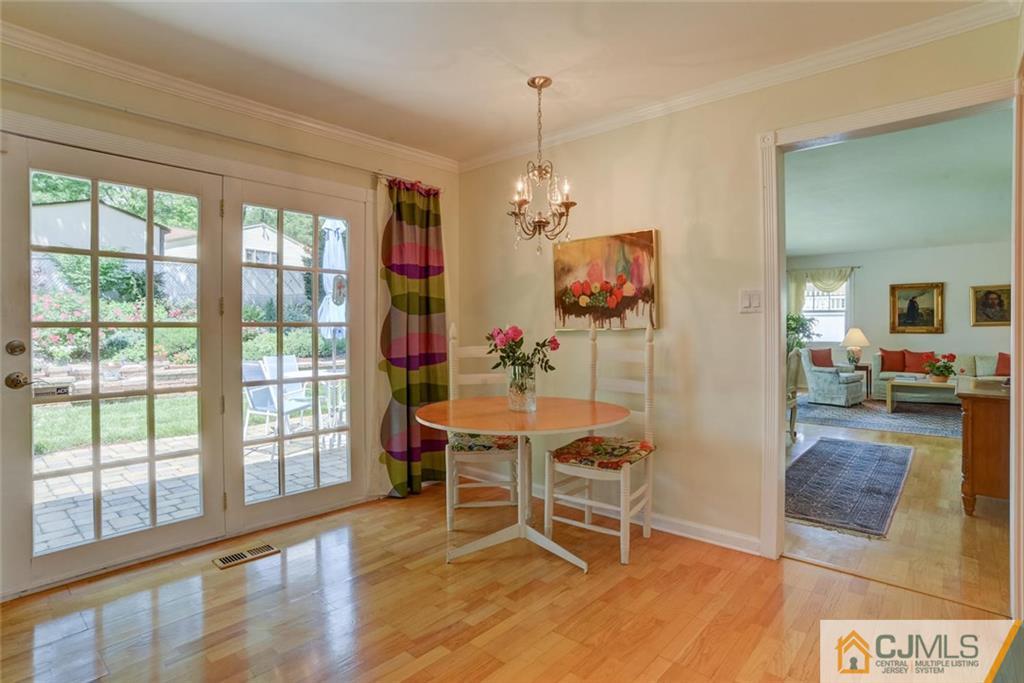 25 Indiana Road Somerset, NJ 08873 - Photo 14 of 25 a dining room with wooden floor a chandelier a glass table and chairs