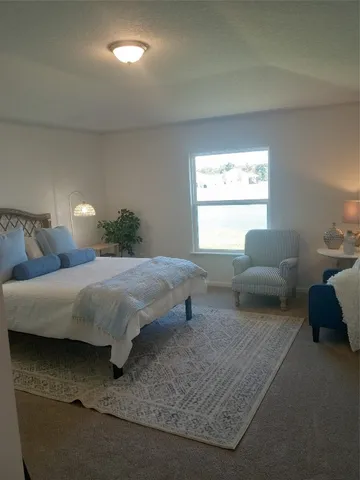 a bedroom with a bed couch and window