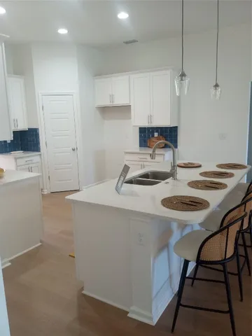 a kitchen with stainless steel appliances a table and chairs in it