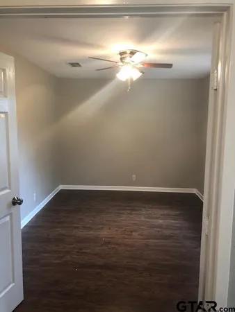 an empty room with wooden floor and entrance
