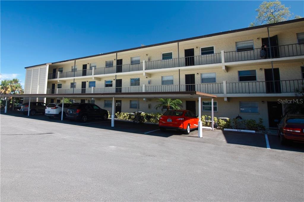 a large building with couple of cars parked in front of it