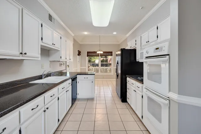 a kitchen with white cabinets and appliances