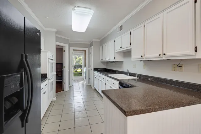 a kitchen with stainless steel appliances granite countertop a refrigerator a stove and a sink
