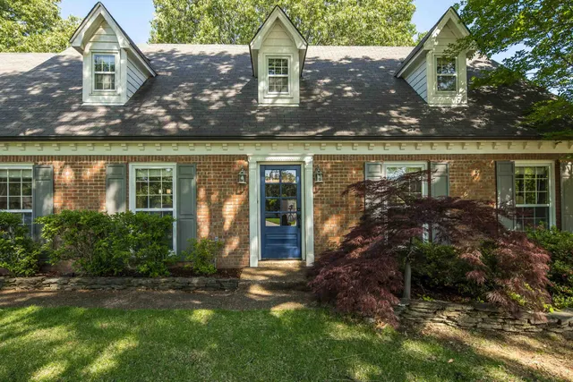 front view of house with a yard and potted plants