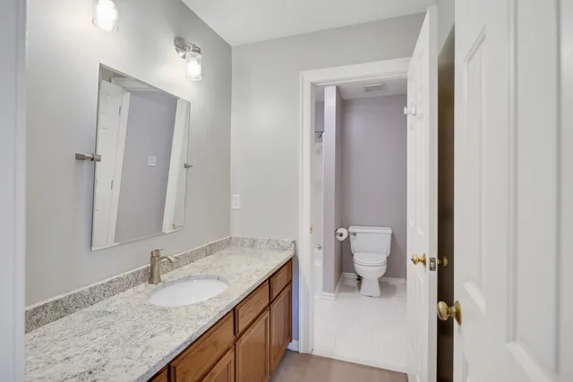 a bathroom with a granite countertop sink and a mirror