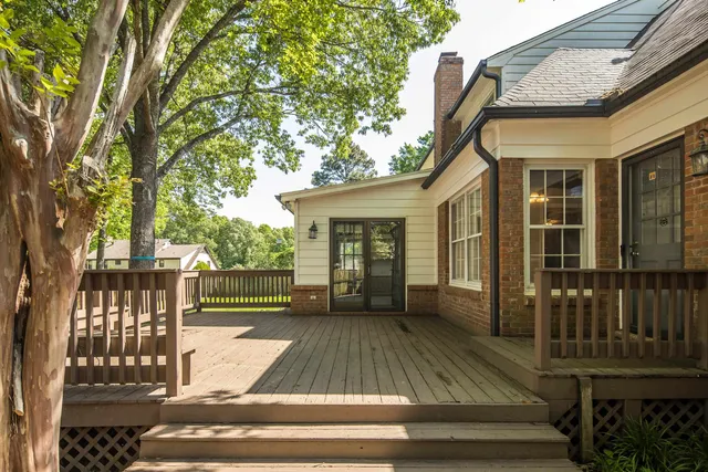 a view of deck house and trees with wooden fence