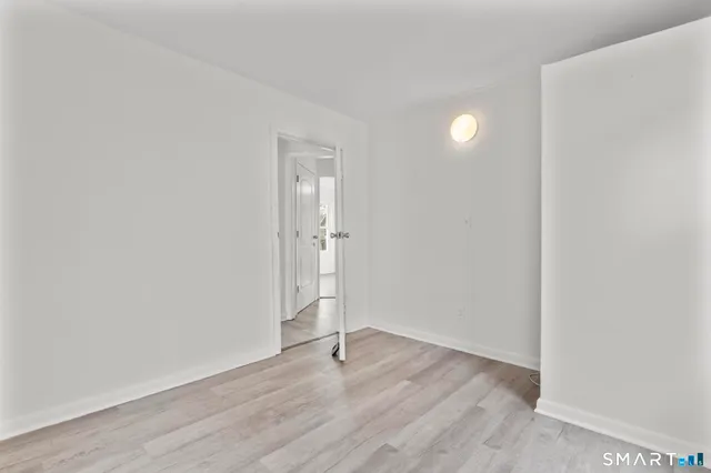 a view of an empty room with wooden floor