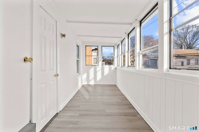 a view of a hallway with wooden floor and windows